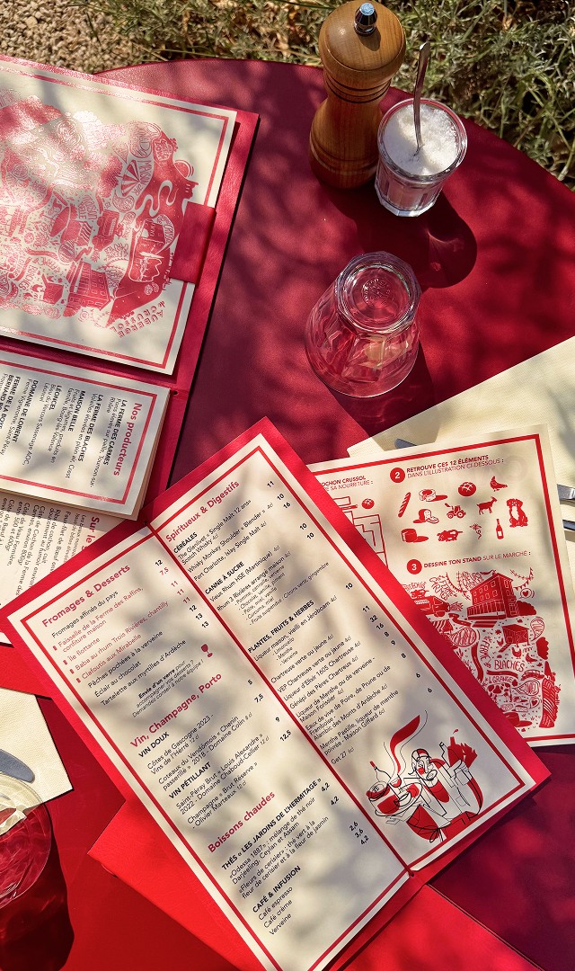 Cartes et menus reproduisant l'identité visuelle sur les tables du restaurant
